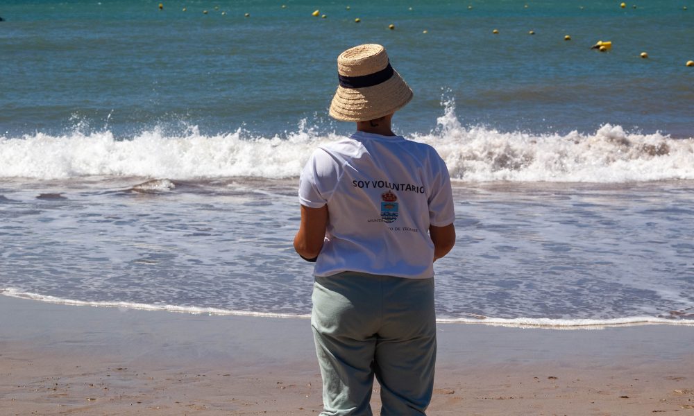 Voluntarios y jóvenes de ADISLAN participando en la jornada de limpieza y surf inclusivo en la Playa de Las Cucharas, Costa Teguise.