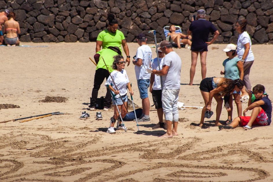 Voluntarios y jóvenes de ADISLAN participando en la jornada de limpieza y surf inclusivo en la Playa de Las Cucharas, Costa Teguise.