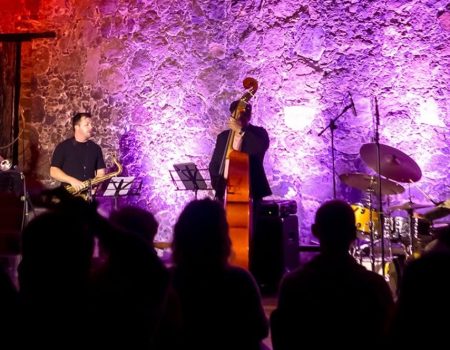 Músicos de la banda de jazz Ancor Miranda Quartet tocando la trompeta, contrabajo y batería.