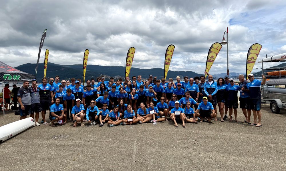 Palistas del Club Piragüismo Marlines celebrando con trofeos y medallas en el podio de Vigo.