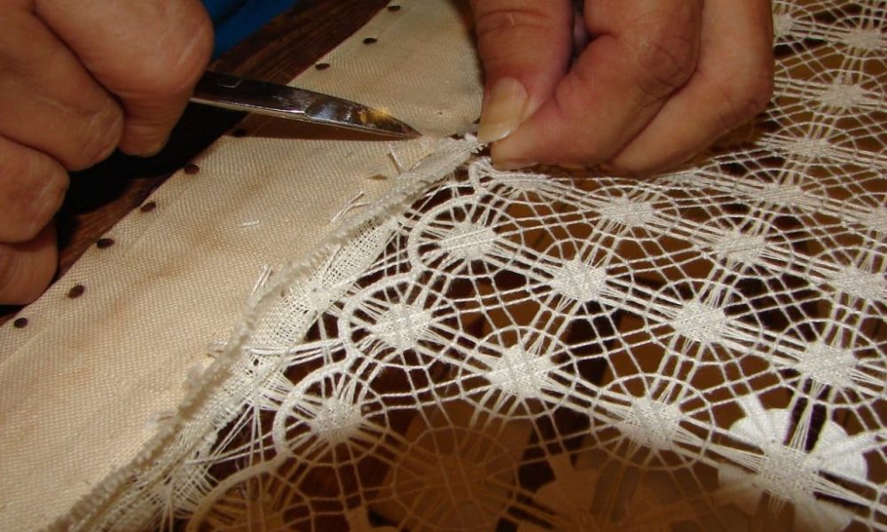 Detalle de un tejido tradicional de calado canario expuesto en una vitrina museística.