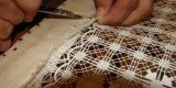 Detalle de un tejido tradicional de calado canario expuesto en una vitrina museística.