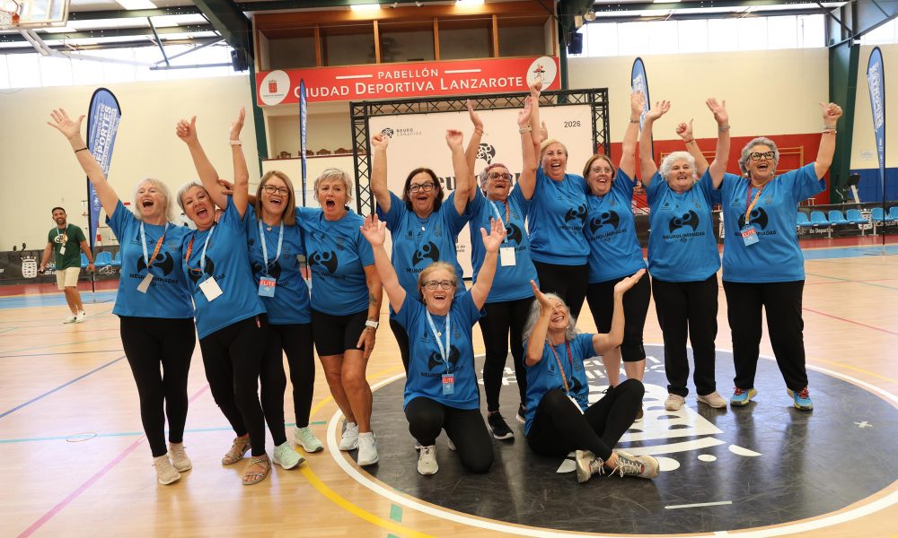 Grupo de mayores del equipo Los Gurfines abrazándose y celebrando con su trofeo en la pista de la Ciudad Deportiva Lanzarote.
