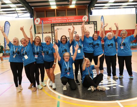 Grupo de mayores del equipo Los Gurfines abrazándose y celebrando con su trofeo en la pista de la Ciudad Deportiva Lanzarote.
