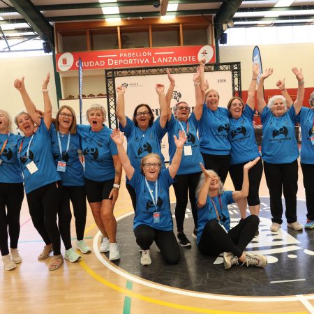 Grupo de mayores del equipo Los Gurfines abrazándose y celebrando con su trofeo en la pista de la Ciudad Deportiva Lanzarote.