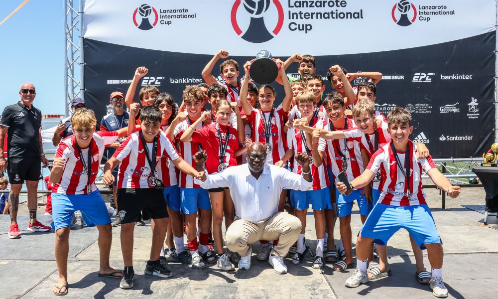 Jugadores del Sevilla FC e Infantil celebrando con el trofeo de campeones en la Ciudad Deportiva de Lanzarote.