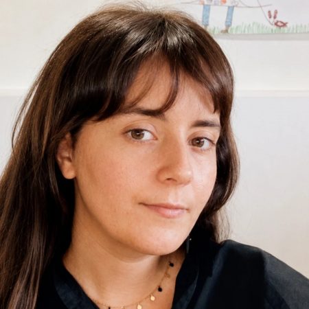 Retrato de la escritora lanzaroteña Lana Corujo sosteniendo su novela de éxito internacional.