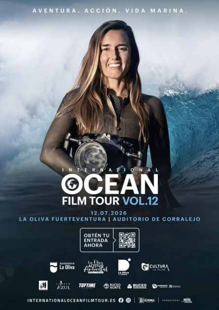 Primer plano de la fotógrafa marina Christa Funk nadando entre grandes olas con su cámara de agua en Hawái.