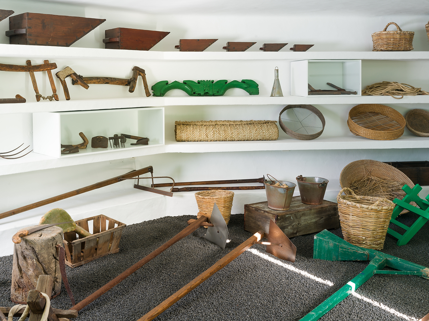 Interior de la vivienda tradicional canaria y exposición de aperos agrícolas en el museo.