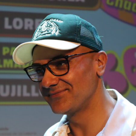 Retrato del humorista Cristito sonriendo durante una actuación en directo.