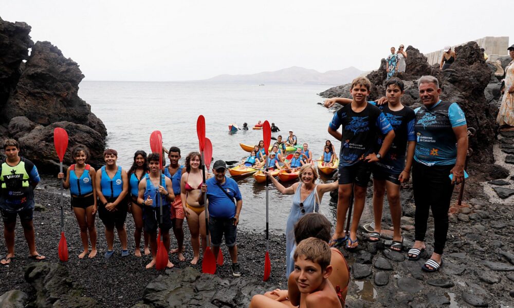Jóvenes disfrutando de actividades acuáticas en Playa Chica, Puerto del Carmen.