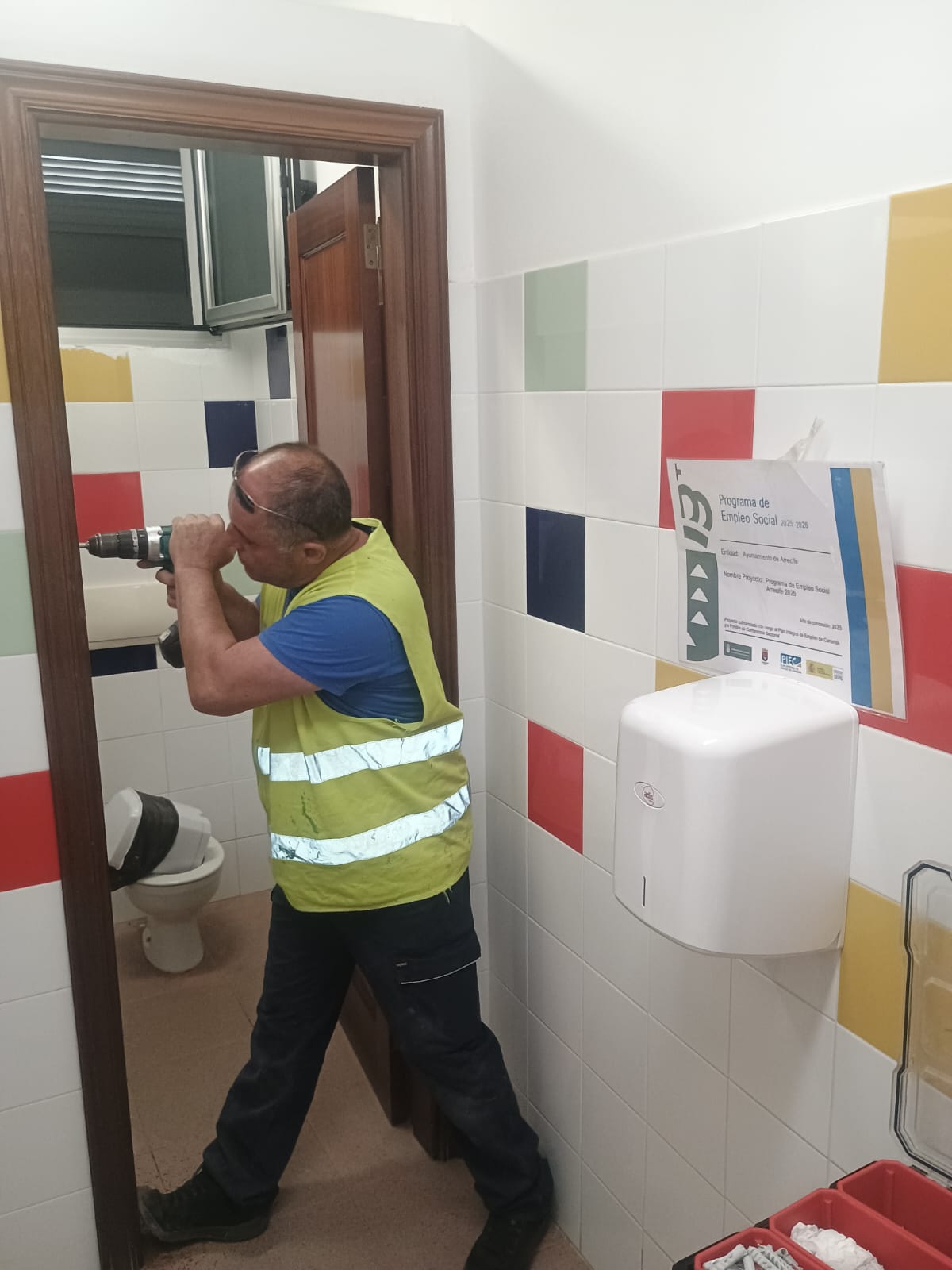 Operarios realizando labores de pintura y mantenimiento en un centro educativo de Arrecife.